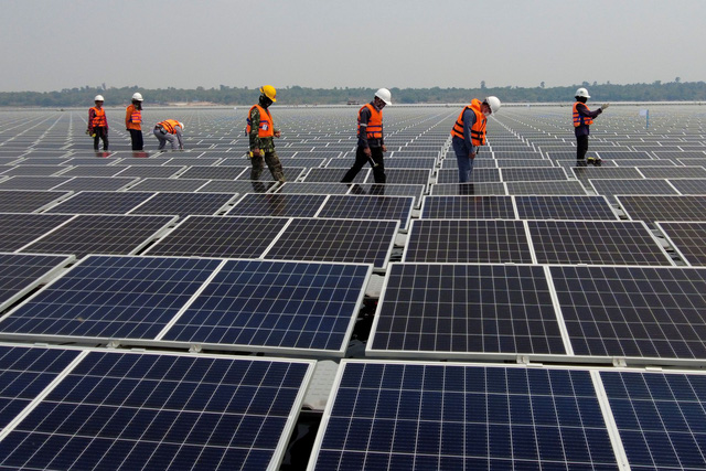 Công nhân đang kiểm tra tấm pin mặt trời tại trang trại điện mặt trời ở đập Sirindhorn